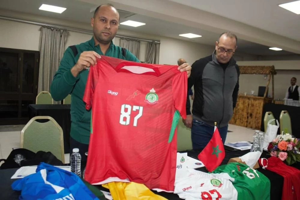 Un responsable de l'organisation du Championnat arabe de handball présentant le maillot du Maroc avec le carte du Royaume avant le coup d'envoi de la compétition.