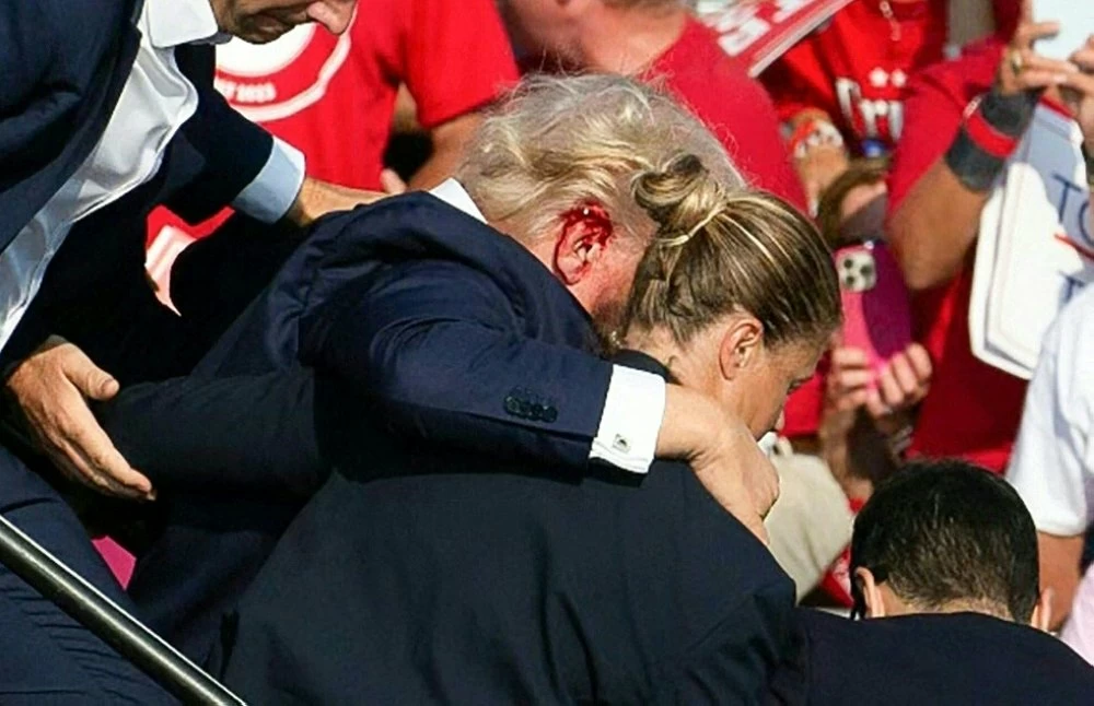 Republican candidate Donald Trump is seen with blood on his face surrounded by secret service agents as he is taken off the stage at a campaign event at Butler Farm Show Inc. in Butler, Pennsylvania, July 13, 2024. Republican candidate Donald Trump was evacuated from the stage at today's rally after what sounded like shots rang out at the event in Pennsylvania, according to AFP.
The former US president was seen with blood on his right ear as he was surrounded by security agents, who hustled him off the stage as he pumped his first to the crowd.
Trump was bundled into an SUV and driven away. (Photo by Rebecca DROKE / AFP)