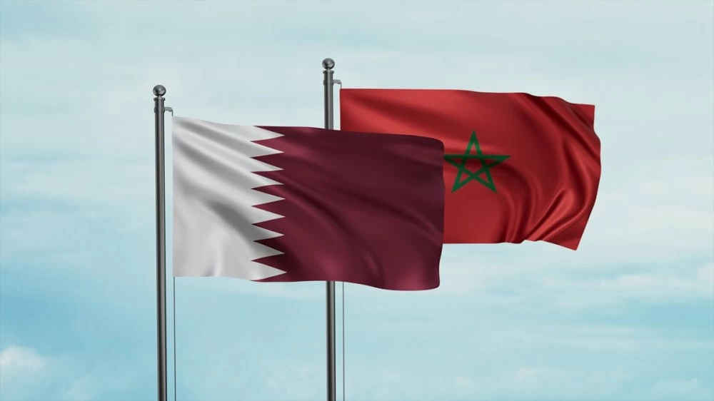 Morocco flag and Qatar flag waving together on blue sky, two country cooperation concept