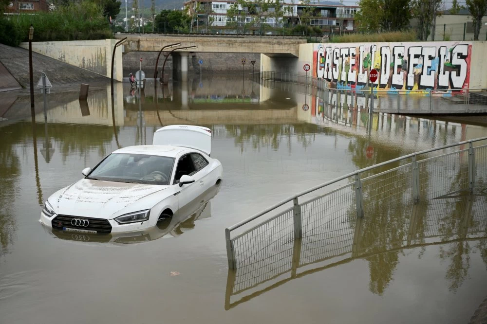 A flooded car is pictured in the Barcelona suburbs of Castelldefels on November 4, 2024 as torrential rain struck Catalonia. Spain dreads more flood deaths as rain pounds Catalonia, where residents received telephone alerts urging the utmost caution, following deadly flooding that left 217 dead, almost all in the eastern Valencia region. (Photo by Josep LAGO / AFP)