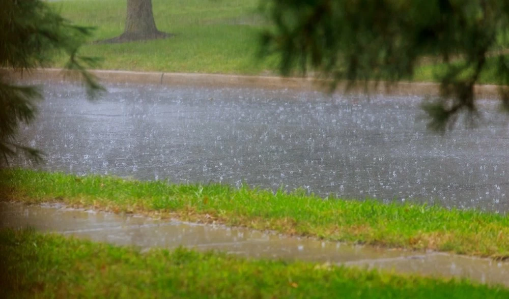 Road during heavy rain. raindrops on water puddles bad weather